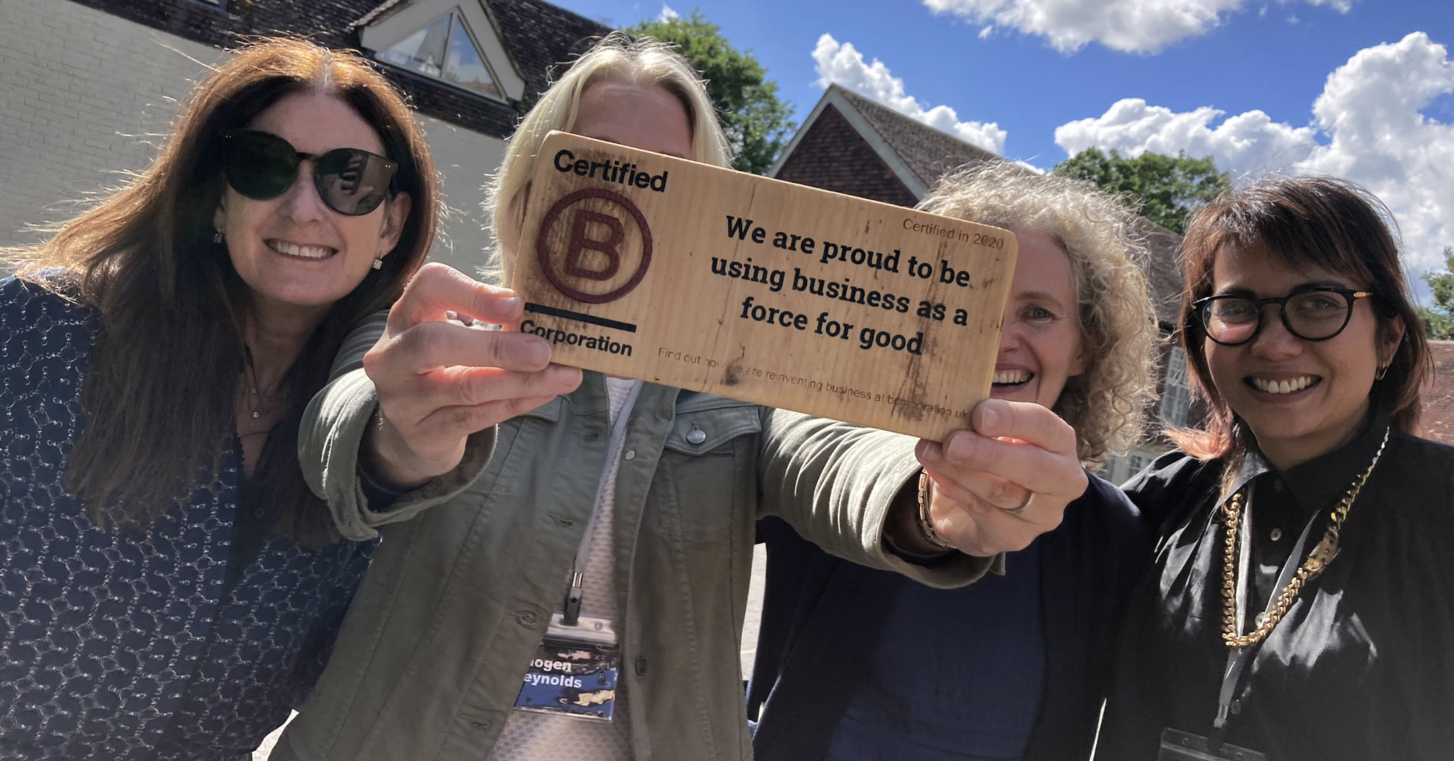 The Oxford SM team holding the wooden B Corporation certification whilst smiling